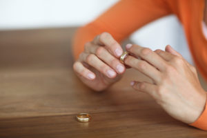 Mid adult woman toying with gold wedding ring on finger